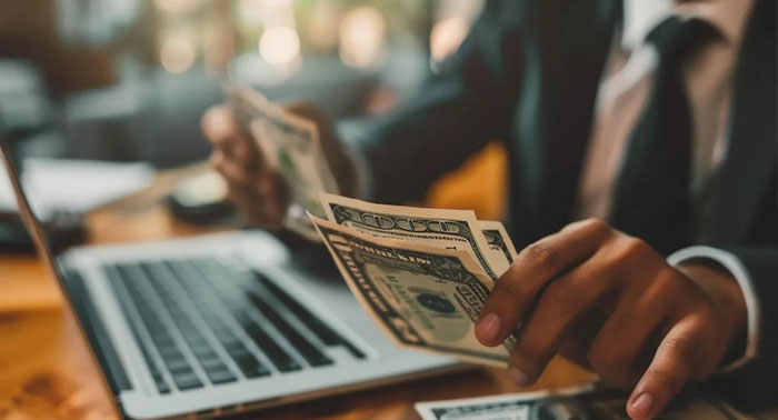 Cozy kitchen scene with a person reviewing payday loan documents on a laptop