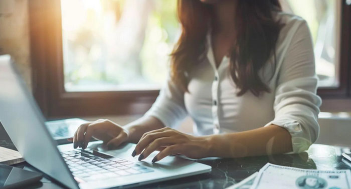 Cozy kitchen scene with a person reviewing payday loan documents on a laptop
